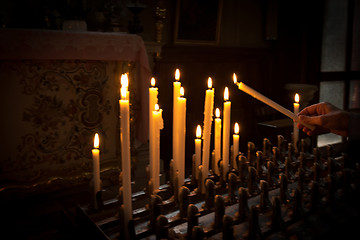 Image showing Woman lighting prayer candle