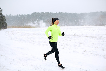 Image showing happy woman running along snow covered winter road