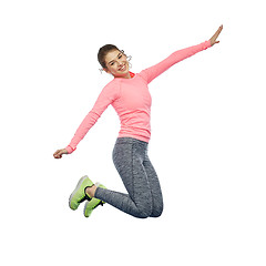 Image showing happy smiling sporty young woman jumping in air