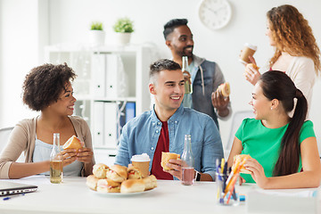 Image showing happy friends or team eating at office party