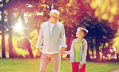 Image showing grandfather and grandson walking at summer park