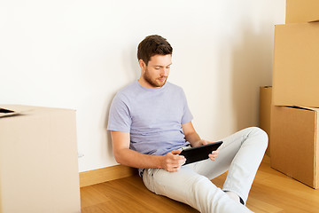 Image showing man with tablet pc and boxes moving to new home