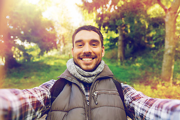 Image showing happy man with backpack taking selfie and hiking