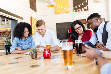 Image showing friends with smartphone, tablet pc and beer at bar