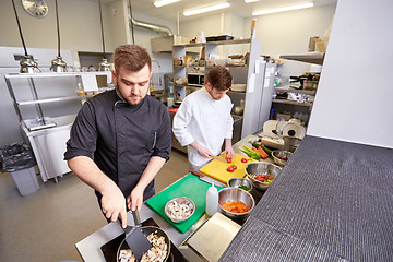 Image showing chef and cook cooking food at restaurant kitchen