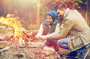 Image showing father and son roasting marshmallow over campfire