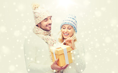 Image showing smiling couple in winter clothes with gift box