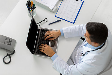 Image showing doctor with cardiogram and laptop at clinic