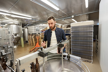 Image showing men with bottles on conveyor at craft beer brewery