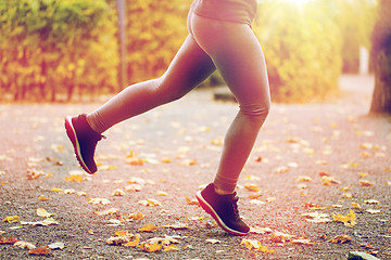 Image showing close up of young woman running in autumn park