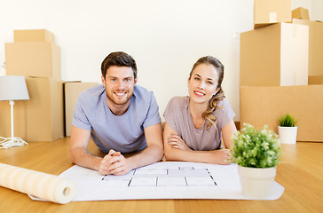 Image showing couple with boxes and blueprint moving to new home