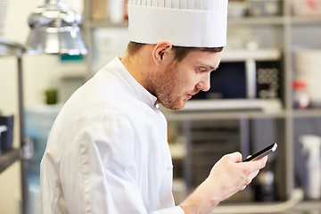 Image showing close up of chef with smartphone at kitchen