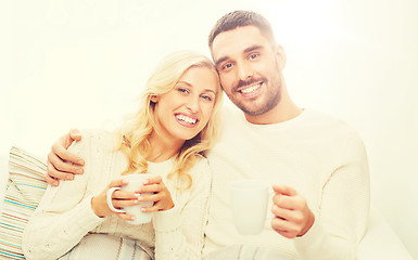 Image showing happy couple with cups drinking tea at home