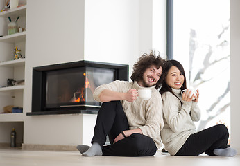 Image showing happy multiethnic couple  in front of fireplace