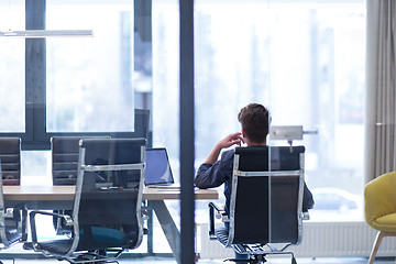 Image showing young businessman relaxing at the desk