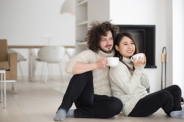 Image showing happy multiethnic couple  in front of fireplace