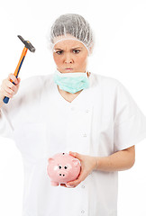 Image showing a woman doctor breaks his piggy bank with a hammer