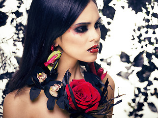 Image showing pretty brunette woman with rose jewelry, black and red, bright m