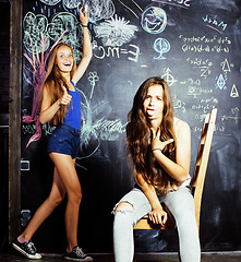 Image showing back to school after summer vacations, two teen girls in classroom with blackboard painted