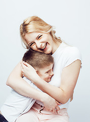 Image showing young modern blond curly mother with cute son together happy smiling family posing cheerful on white background, lifestyle people concept, sister and brother friends 