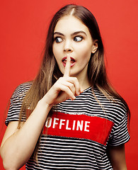 Image showing young pretty emitonal posing teenage girl on bright red background, happy smiling lifestyle people concept 