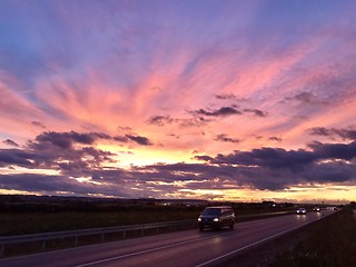 Image showing Cars driving during dramatic sunset