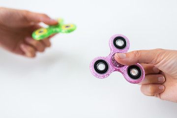 Image showing close up of two hands playing with fidget spinners