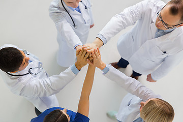 Image showing group of doctors making high five at hospital