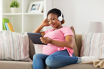 Image showing pregnant woman in headphones with tablet pc