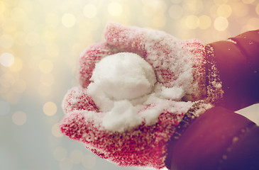 Image showing close up of woman holding snowball outdoors