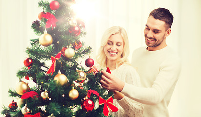 Image showing happy couple decorating christmas tree at home