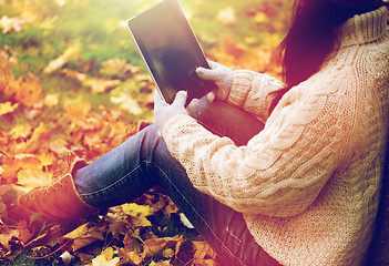 Image showing close up of woman with tablet pc in autumn park
