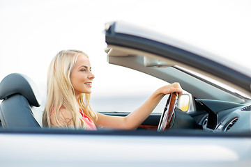 Image showing happy young woman driving convertible car