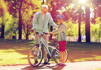 Image showing grandfather and boy with bicycle at summer park