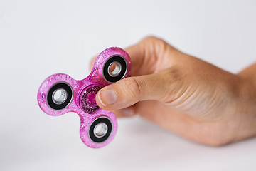 Image showing close up of hand playing with fidget spinner