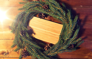 Image showing natural green fir branch wreath and wooden board