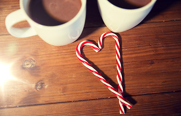 Image showing christmas candy canes and cups on wooden table