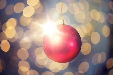 Image showing close up of red christmas ball over golden lights