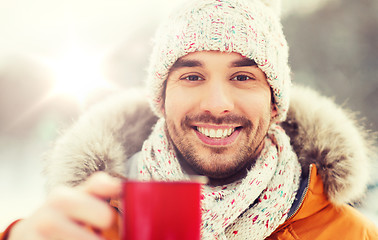 Image showing happy man with tea cup outdoors in winter