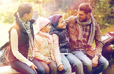 Image showing happy family sitting on bench and talking at camp