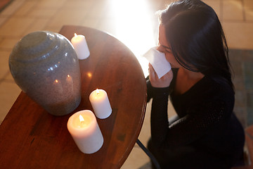 Image showing woman with cremation urn at funeral in church