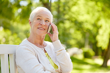 Image showing happy senior woman calling on smartphone in summer