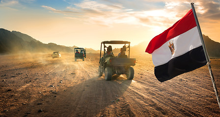 Image showing Flag and buggies in desert