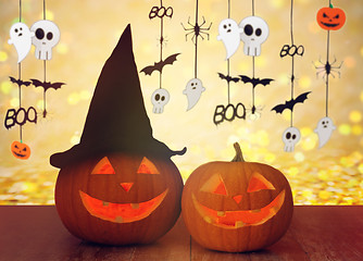 Image showing carved pumpkins in witch hat and halloween garland