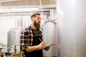 Image showing man with clipboard at craft brewery or beer plant