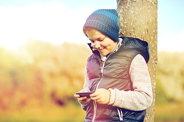 Image showing happy boy playing game on smartphone outdoors