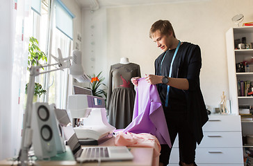 Image showing fashion designer with cloth making dress at studio