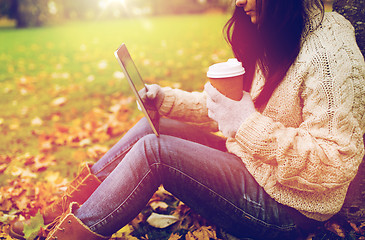 Image showing woman with tablet pc and coffee in autumn park