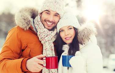 Image showing happy couple with tea cups over winter landscape