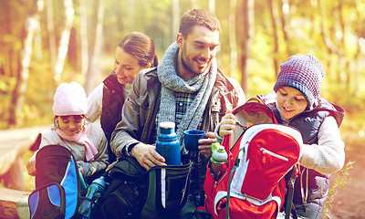 Image showing happy family with backpacks and thermos at camp